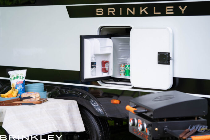 | Model I 294 Travel Trailers 47 Luxury Travel Trailer's camp site with a camp-side 12-volt refrigerator and grill ready for outdoor cooking and entertaining.