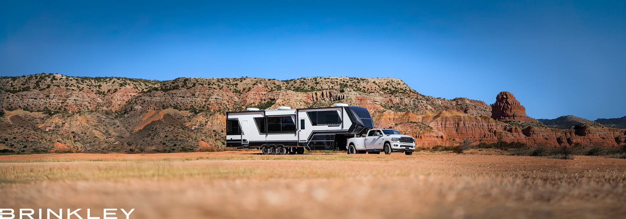 | Model G Fifth Wheel Toy Hauler Line 119 Brinkley Model G Luxury Fifth Wheel Toy Hauler RVing in Palo Duro Canyon State Park in Texas towed by a White Truck