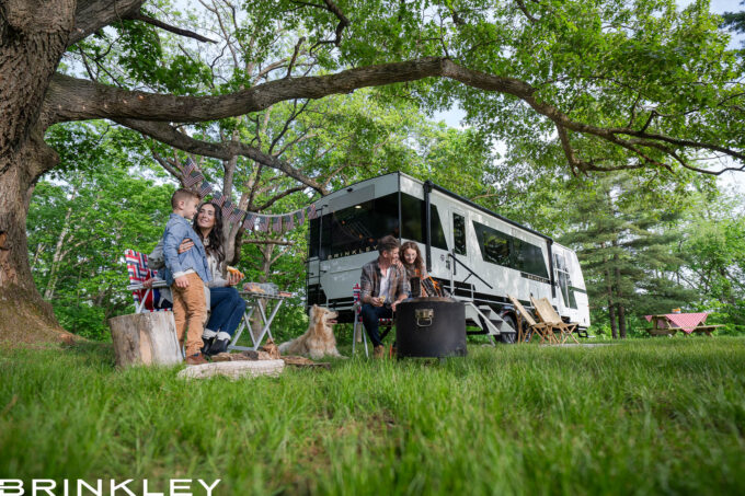 | Model I 294 Travel Trailers 40 Family Friendly Camping around a luxury Travel Trailer RV with kids playing with the family and dog around a campfire at their campsite