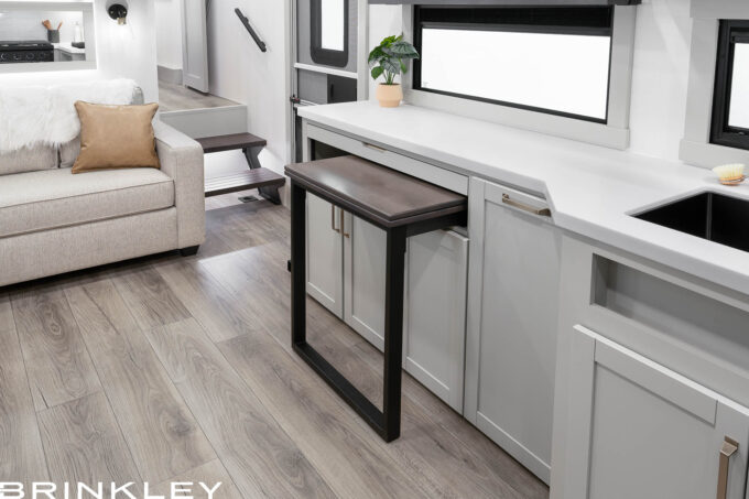 | Model Z 2810 Fifth Wheels 21 Luxury 2026 Brinkley Model Z 2810 bunkhouse Fifth Wheel dining room featuring the versatile Dinesk sliding table stowed against the wall to create an open floor plan.